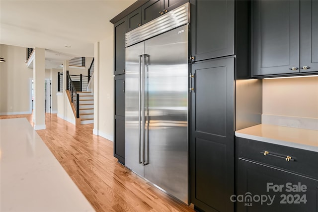 kitchen with stainless steel built in fridge and light hardwood / wood-style floors