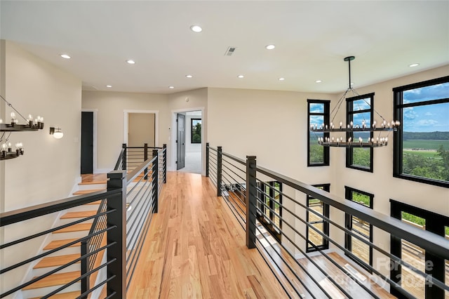 hall featuring an inviting chandelier and light hardwood / wood-style floors