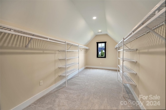 spacious closet with vaulted ceiling and carpet flooring