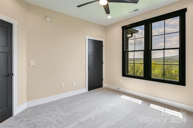 carpeted empty room featuring ceiling fan