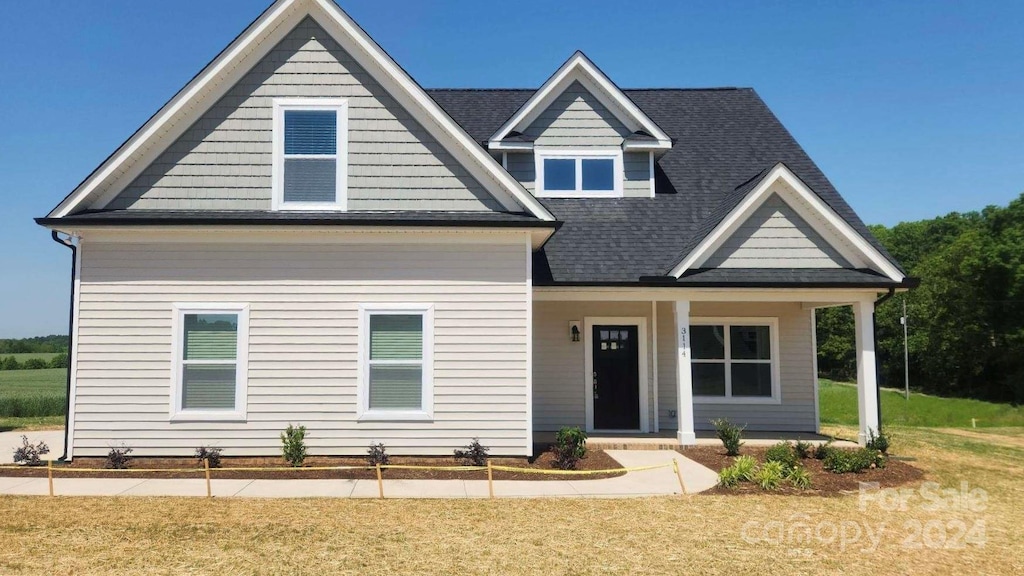 craftsman-style home featuring covered porch and a front yard