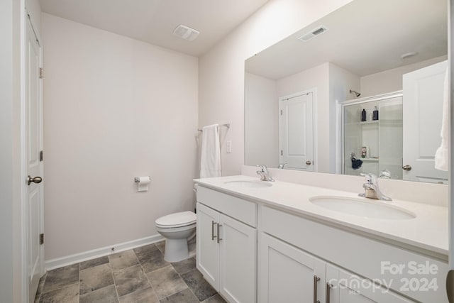 bathroom with walk in shower, vanity, and toilet