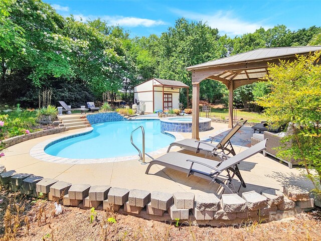 view of swimming pool featuring an outbuilding, a patio area, and a gazebo