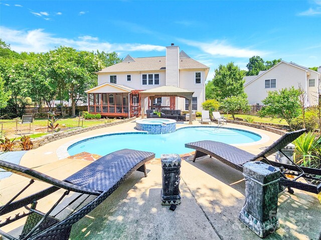 view of pool with an in ground hot tub, a gazebo, a sunroom, and a patio