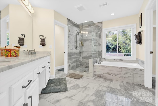 bathroom featuring vanity and independent shower and bath