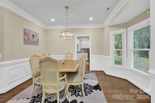 dining room with dark hardwood / wood-style flooring, ornamental molding, and a notable chandelier