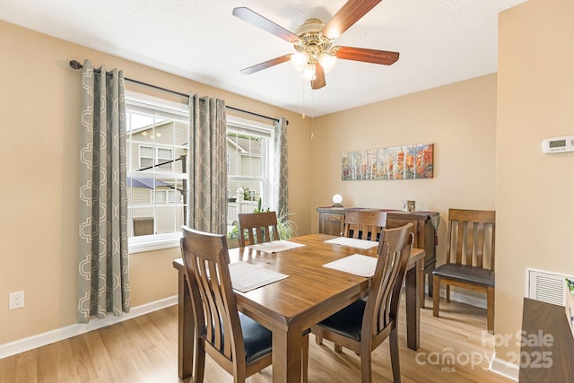 dining room featuring ceiling fan, light hardwood / wood-style flooring, and a textured ceiling