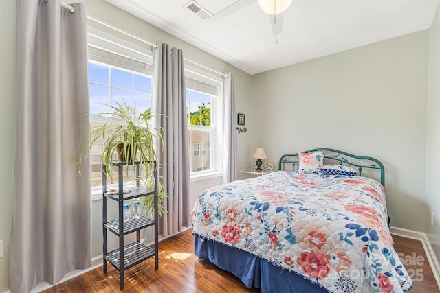 bedroom featuring ceiling fan, hardwood / wood-style floors, and a textured ceiling