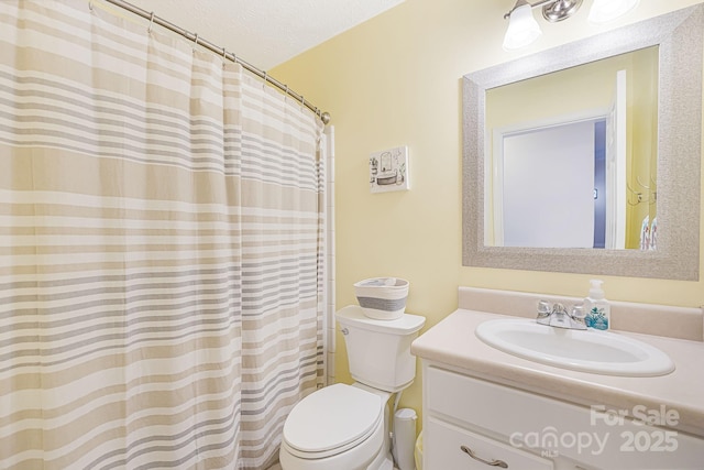 bathroom featuring vanity, a textured ceiling, and toilet