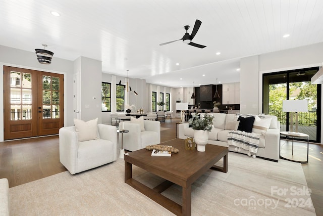 living room with light hardwood / wood-style floors, wooden ceiling, a wealth of natural light, and french doors