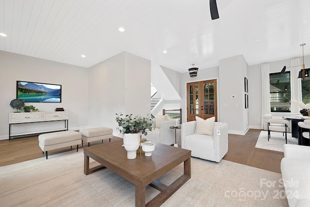 living room with wooden ceiling, light hardwood / wood-style flooring, french doors, and a healthy amount of sunlight