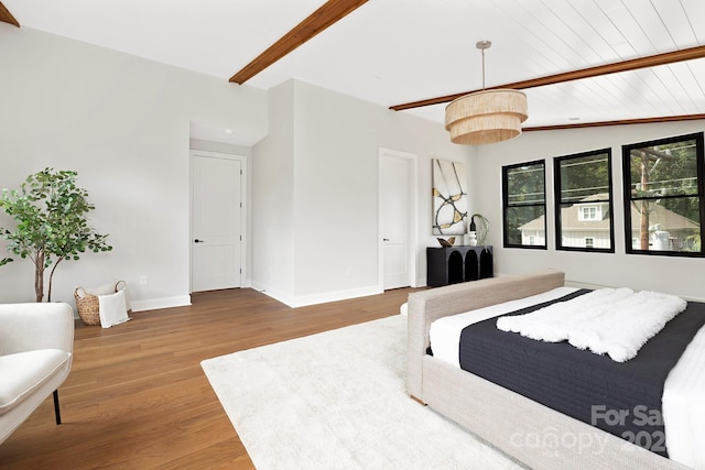 bedroom featuring vaulted ceiling with beams and hardwood / wood-style flooring