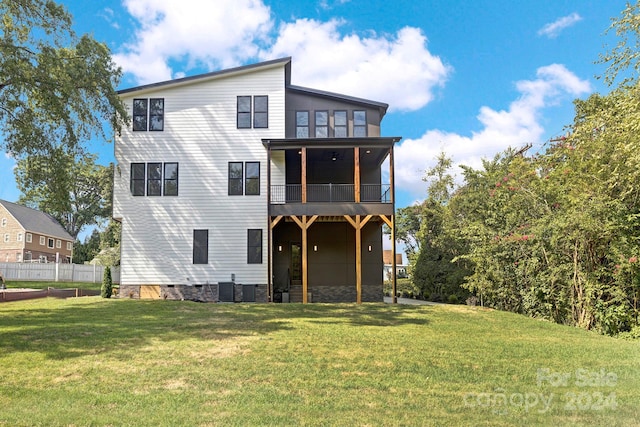 view of front facade featuring a front yard, ceiling fan, central air condition unit, and a sunroom