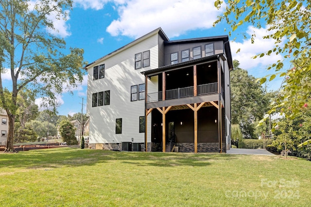 rear view of house featuring a yard and central AC