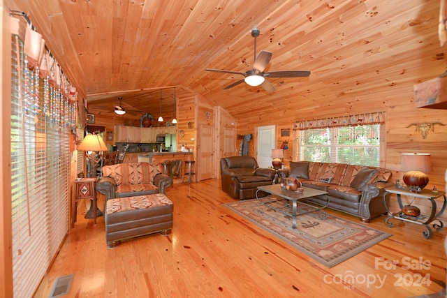 living room featuring vaulted ceiling, light hardwood / wood-style flooring, wooden walls, ceiling fan, and wooden ceiling