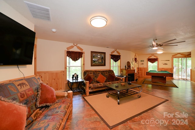 living room featuring pool table, ceiling fan, and wood walls