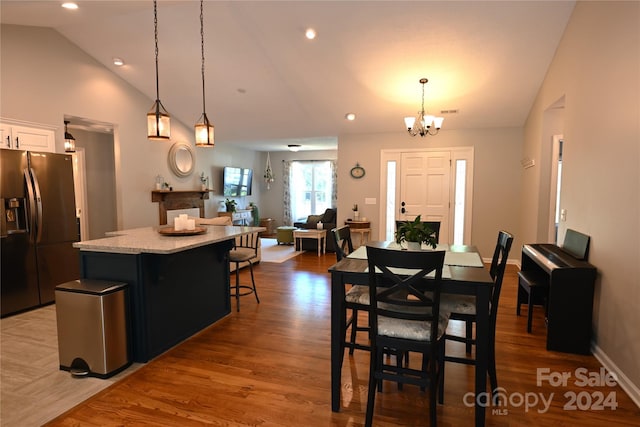 dining area featuring lofted ceiling, dark wood-type flooring, and a notable chandelier