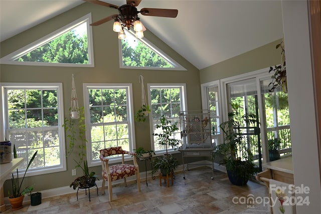 sunroom featuring ceiling fan, a healthy amount of sunlight, and vaulted ceiling