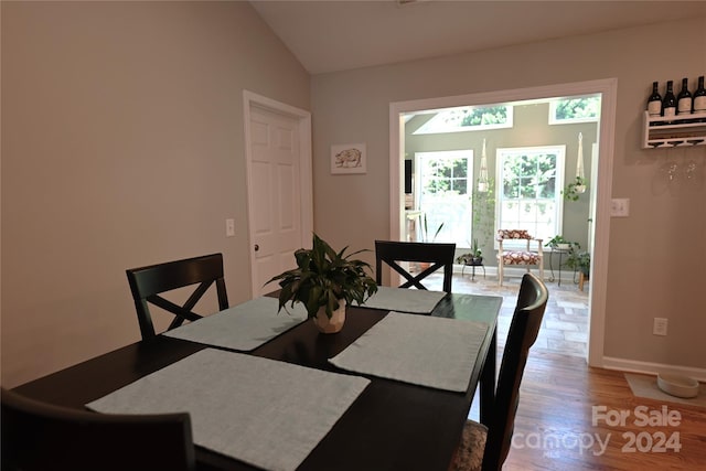 dining area with hardwood / wood-style floors and vaulted ceiling