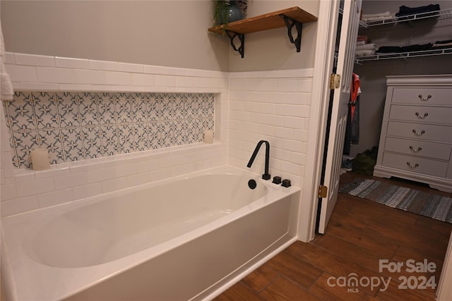 bathroom with wood-type flooring and a bathtub