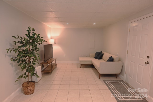 tiled living room featuring a paneled ceiling