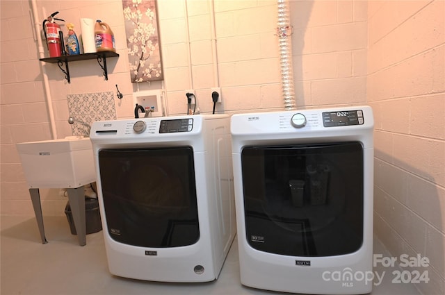 clothes washing area with sink and washing machine and clothes dryer