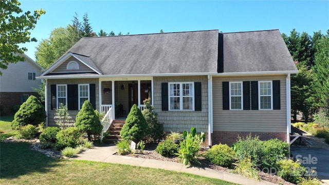 view of front of home featuring brick siding and a shingled roof