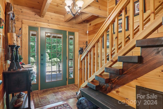 foyer entrance with a wealth of natural light, wood ceiling, wooden walls, and beamed ceiling