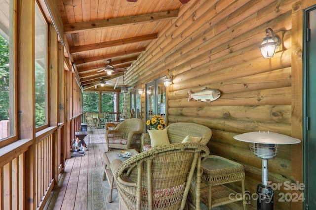 sunroom with ceiling fan, vaulted ceiling with beams, and wooden ceiling