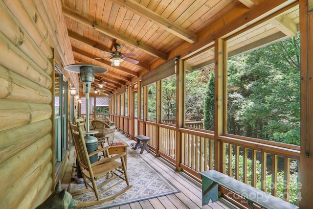 unfurnished sunroom with wooden ceiling, ceiling fan, and beamed ceiling