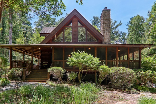 rear view of property featuring a sunroom