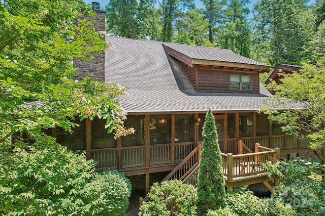 back of property with a sunroom