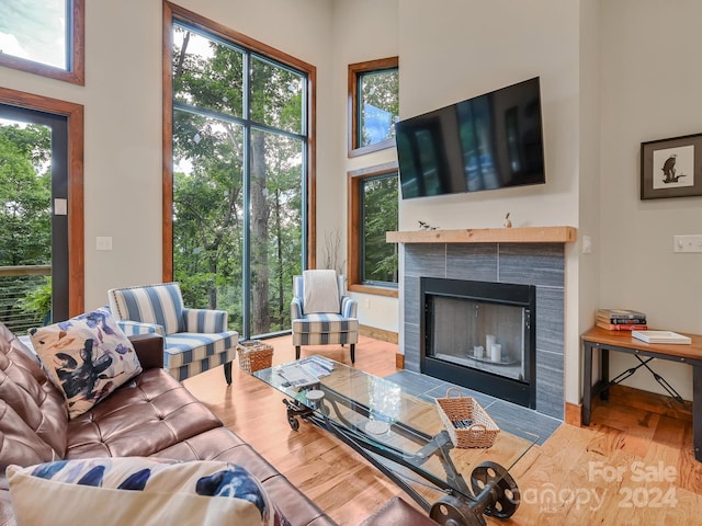 living room featuring a tiled fireplace and hardwood / wood-style flooring