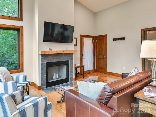 living room with light hardwood / wood-style flooring and a tiled fireplace