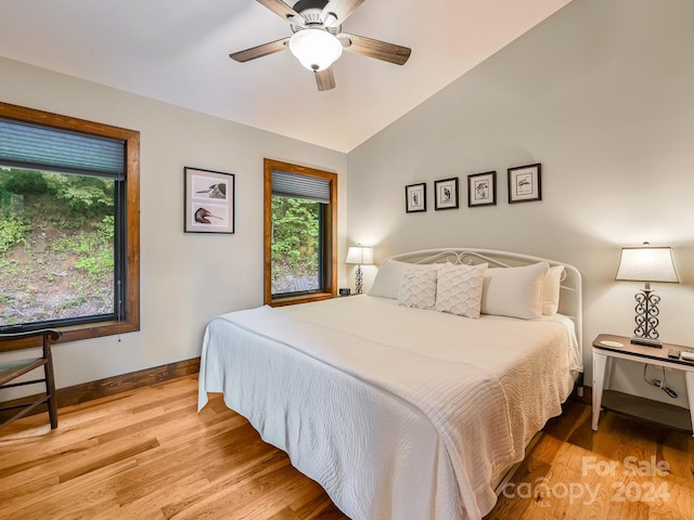 bedroom featuring ceiling fan, lofted ceiling, and light wood-type flooring