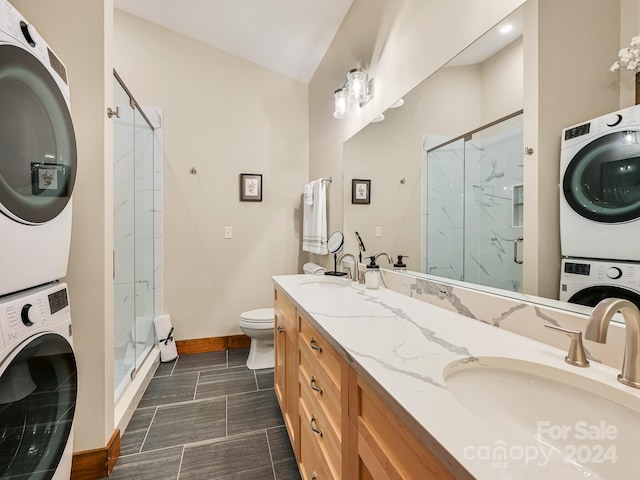 bathroom with an enclosed shower, stacked washer and clothes dryer, lofted ceiling, and vanity