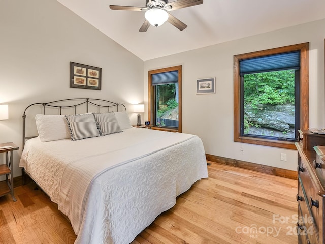 bedroom with ceiling fan, light hardwood / wood-style floors, and vaulted ceiling