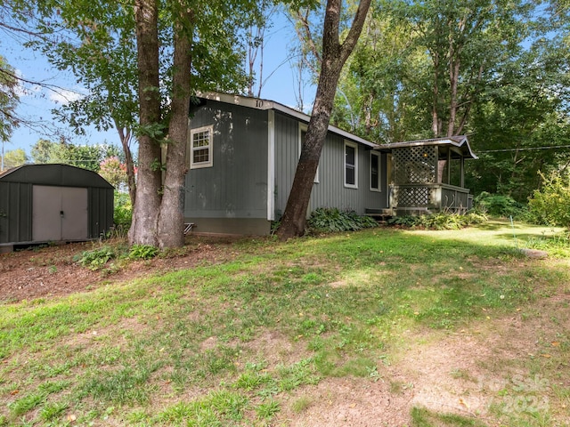 view of property exterior with an outbuilding, a yard, and a shed