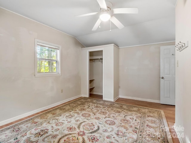 unfurnished bedroom featuring lofted ceiling, light hardwood / wood-style flooring, ceiling fan, and a closet