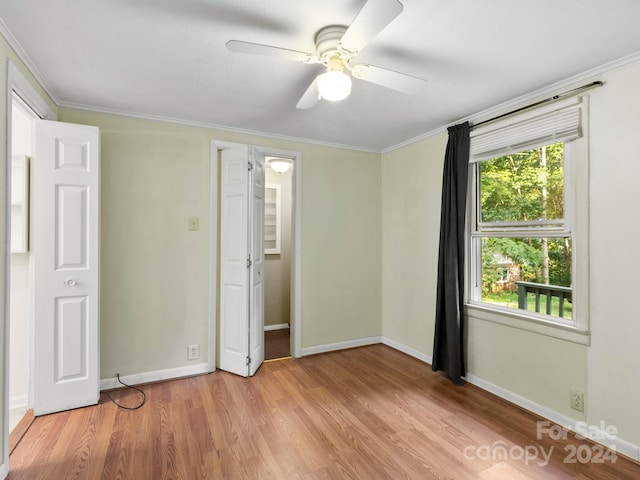 unfurnished bedroom featuring ceiling fan, ornamental molding, and hardwood / wood-style floors