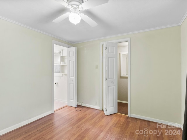 unfurnished bedroom with ceiling fan, a walk in closet, a closet, and hardwood / wood-style flooring