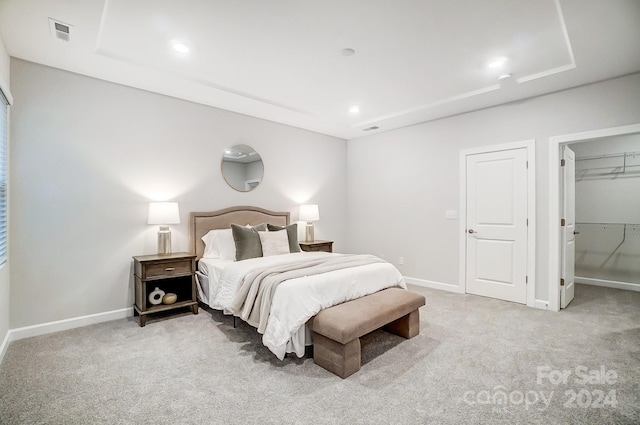 carpeted bedroom with a walk in closet and a closet