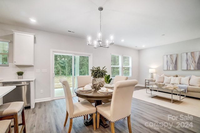 dining space featuring a notable chandelier and light hardwood / wood-style floors