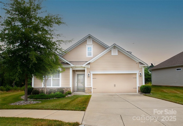 craftsman house with a yard and a garage