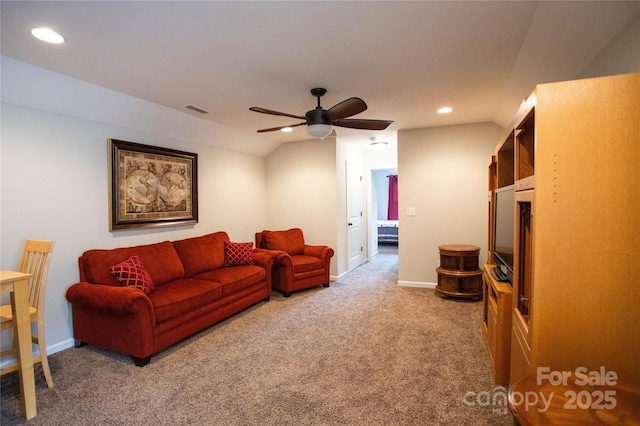 carpeted living room with ceiling fan and vaulted ceiling