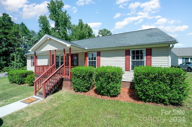 ranch-style house with covered porch and a front yard