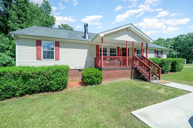 ranch-style house featuring covered porch and a front yard