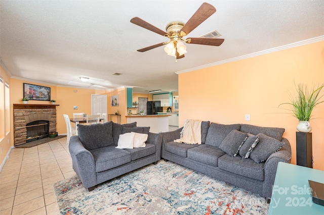 tiled living room with a fireplace, a textured ceiling, ceiling fan, and ornamental molding