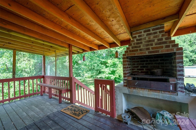 wooden deck with an outdoor brick fireplace