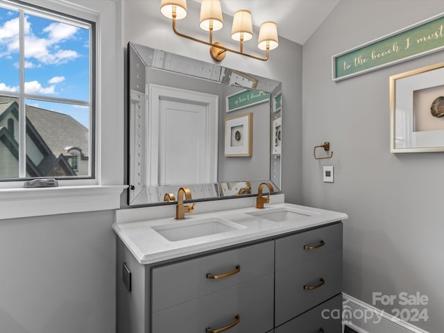 bathroom featuring vanity and lofted ceiling